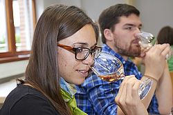 Studentin riecht an ihrem Weinglas