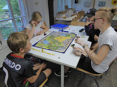 Kinder und Betreuer spielen ein Brettspiel