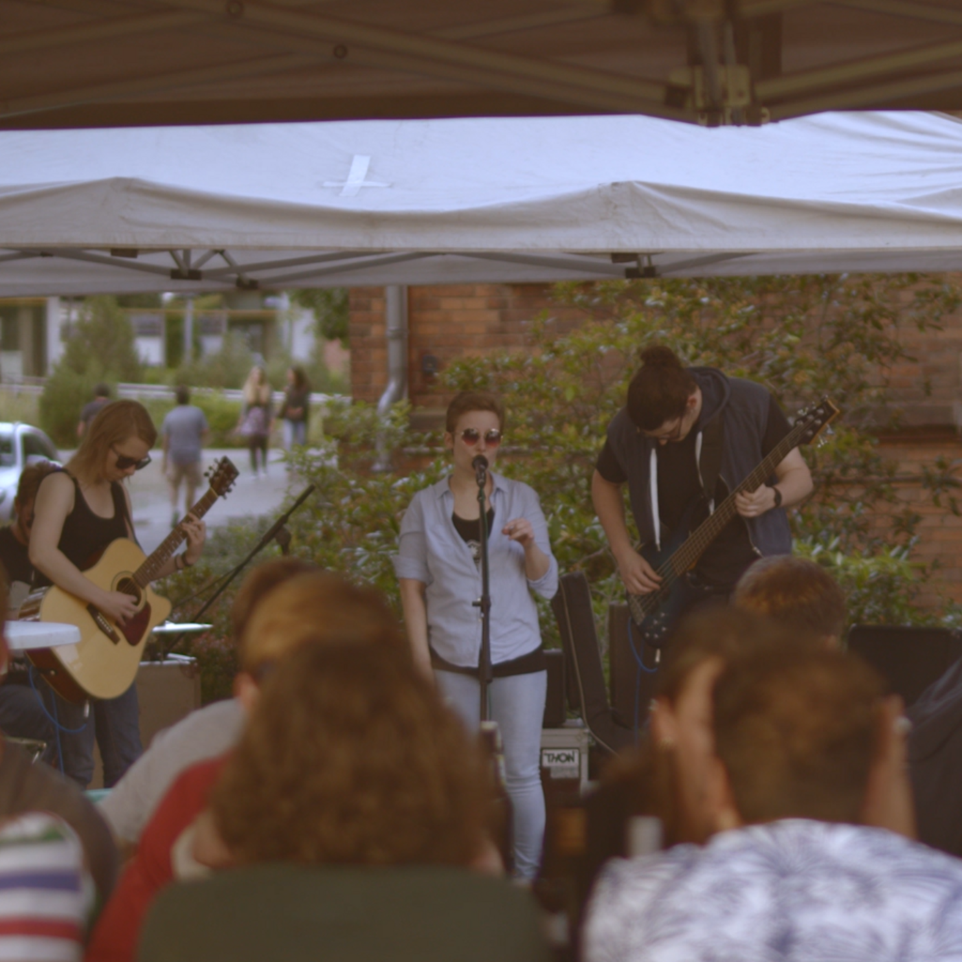 AStA-Band Junge Menschen sitzen vor einem Zelt in dem eine Band spielt. © Hochschschule Geisenheim