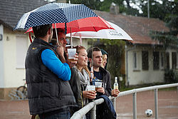 Publikum mit Regenschirmen