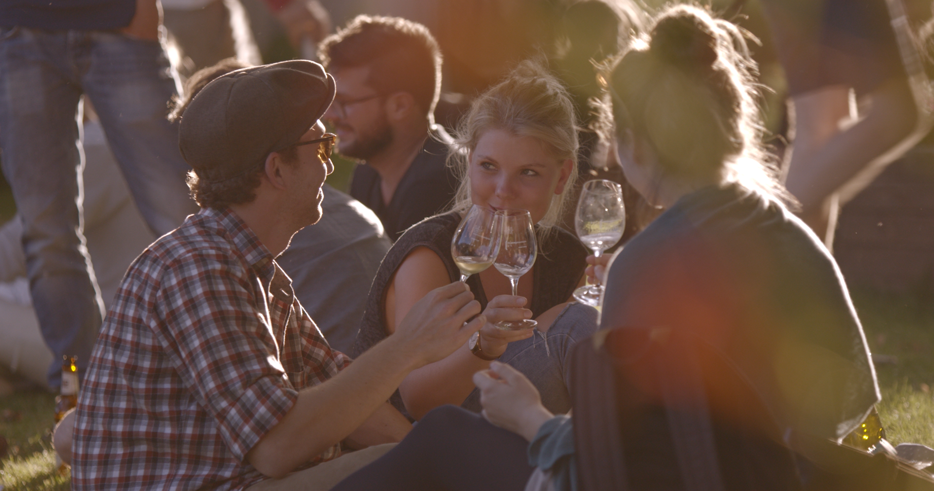 Eine Gruppe junger Menschen sitzt zusammen und stößt mit Wein an. © Hochschschule Geisenheim